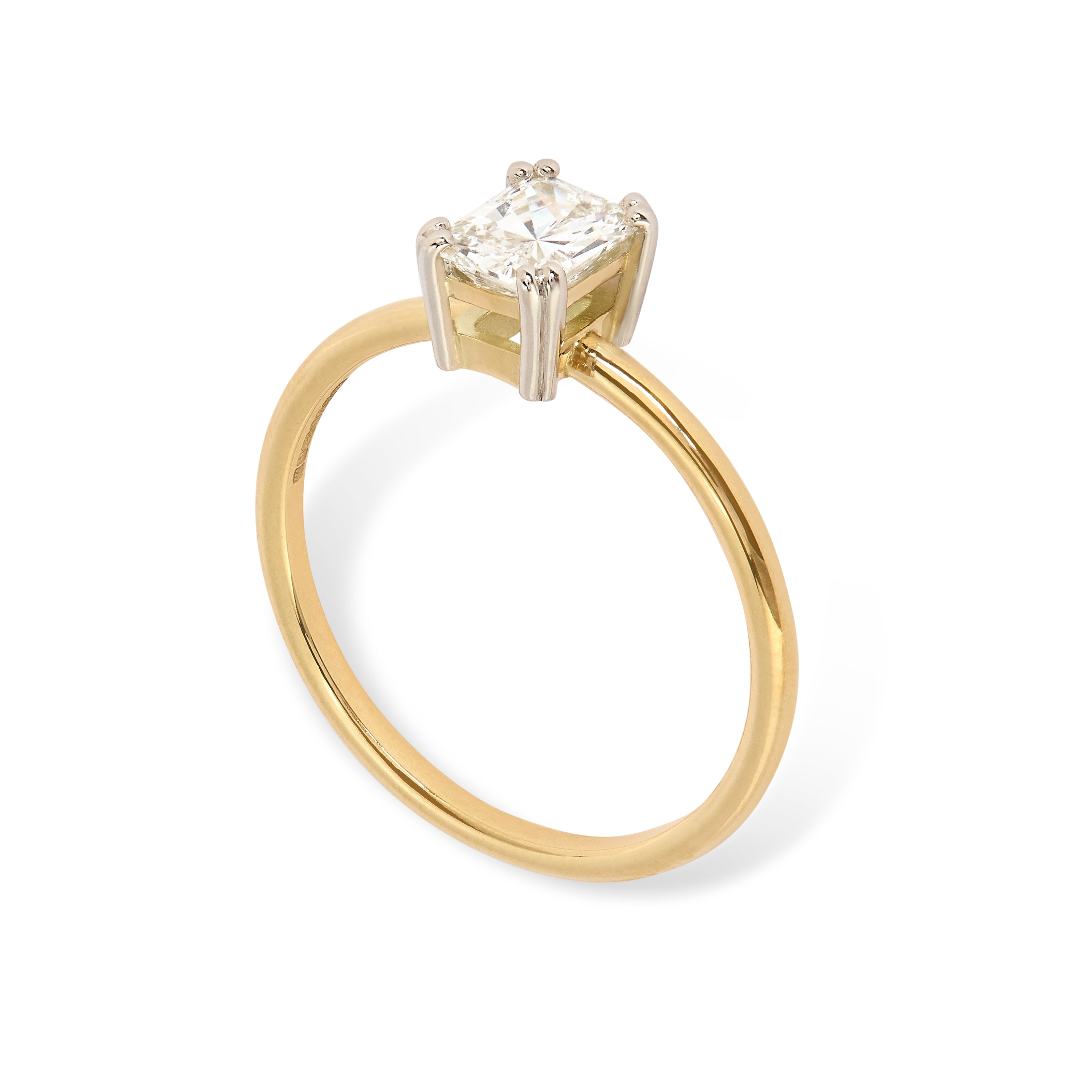 3/4 view of a Radiant diamond solitaire engagement ring on a white background. Set in an unusual 8 claw platinum setting with round gold band. Designed by London based engagement ring designer Antonia Guise