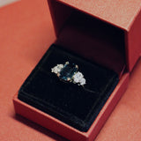 A teal sapphire, one of a kind, engagement ring, designed by jewellery designer Antonia Guise in it's ring box.